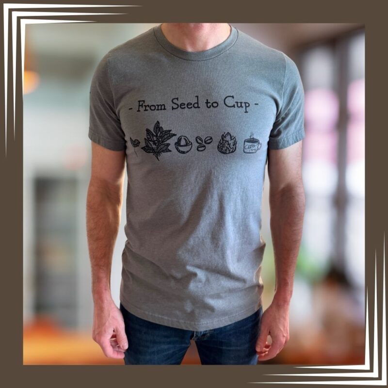 Man wearing heather gray Cups "From Seed to Cup" t-shirt featuring coffee journey illustrations from plant to cup